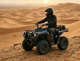 Quad bike rider on a desert ridge in golden morning light